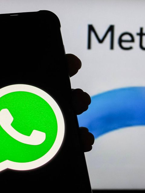 Ein Handy Display mit WhatsApp-Symbol wird vor das META AI-Symbol gehalten