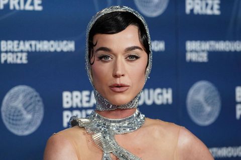 Popstar Katy Perry posiert im glitzernden, silbernen Astronauten-Look auf einem roten Teppich