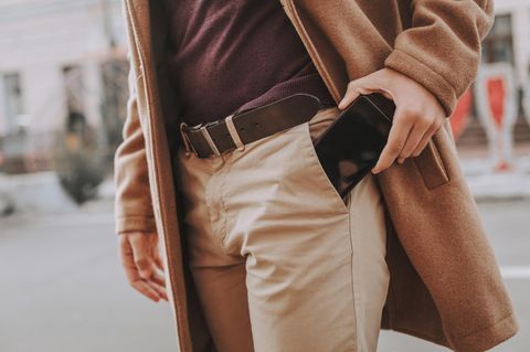 Ein Mann steckt sein Handy in die Hosentasche