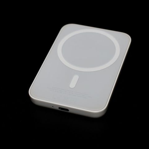 Eine MagSafe-Powerbank liegt auf einem dunklen Tisch