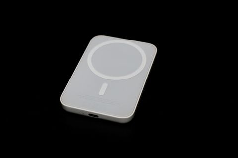 Eine MagSafe-Powerbank liegt auf einem dunklen Tisch