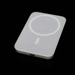 Eine MagSafe-Powerbank liegt auf einem dunklen Tisch