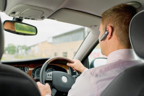 Caucasian businessman with headset driving ca
