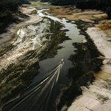 Ein Boot fährt auf dem fast ausgetrockneten Amazonas