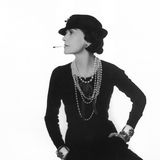 Coco Chanel 1935, sie trägt einen Hut, blickt zur Seite und hat eine Zigarette im Mund