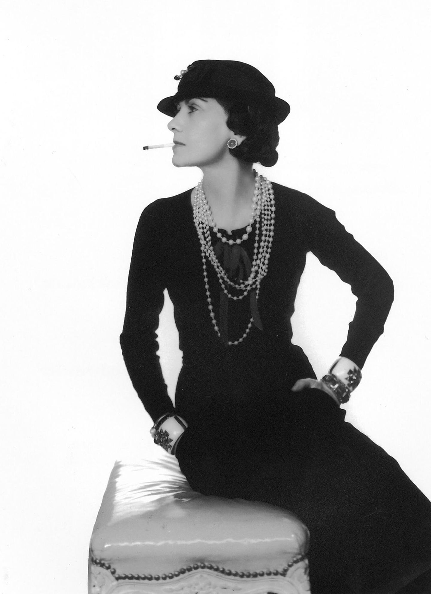 Coco Chanel 1935, sie trägt einen Hut, blickt zur Seite und hat eine Zigarette im Mund