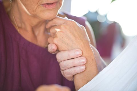 Eine Frau hält die Hand ihres an Demenz erkrankten Mannes