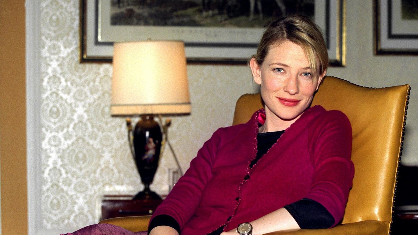 Cate Blanchett im roten Kostüm im Hotel Atlantic auf einem Sessel.