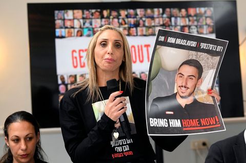 Eine Frau hält ein Plakat mit einem Foto der israelischen Geisel Rom Braslavski hoch