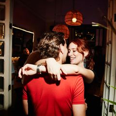 Ein junger Mann und eine junge Frau flirten auf einer Party miteinander