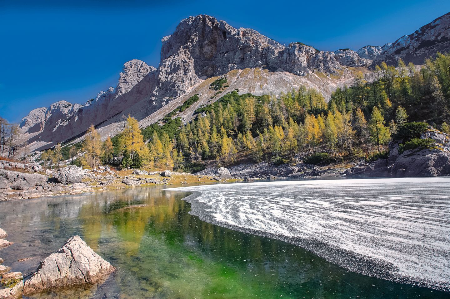 Klares Wasser und hohe Gipfel See vor einem Berggipfel