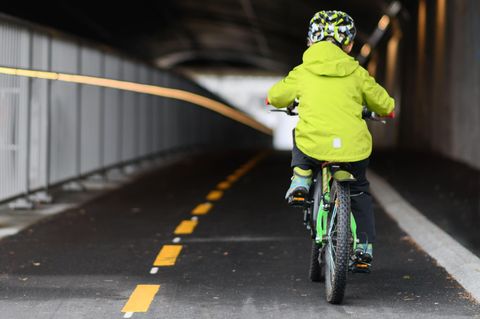 Child cycling on cycling lane in a small European city