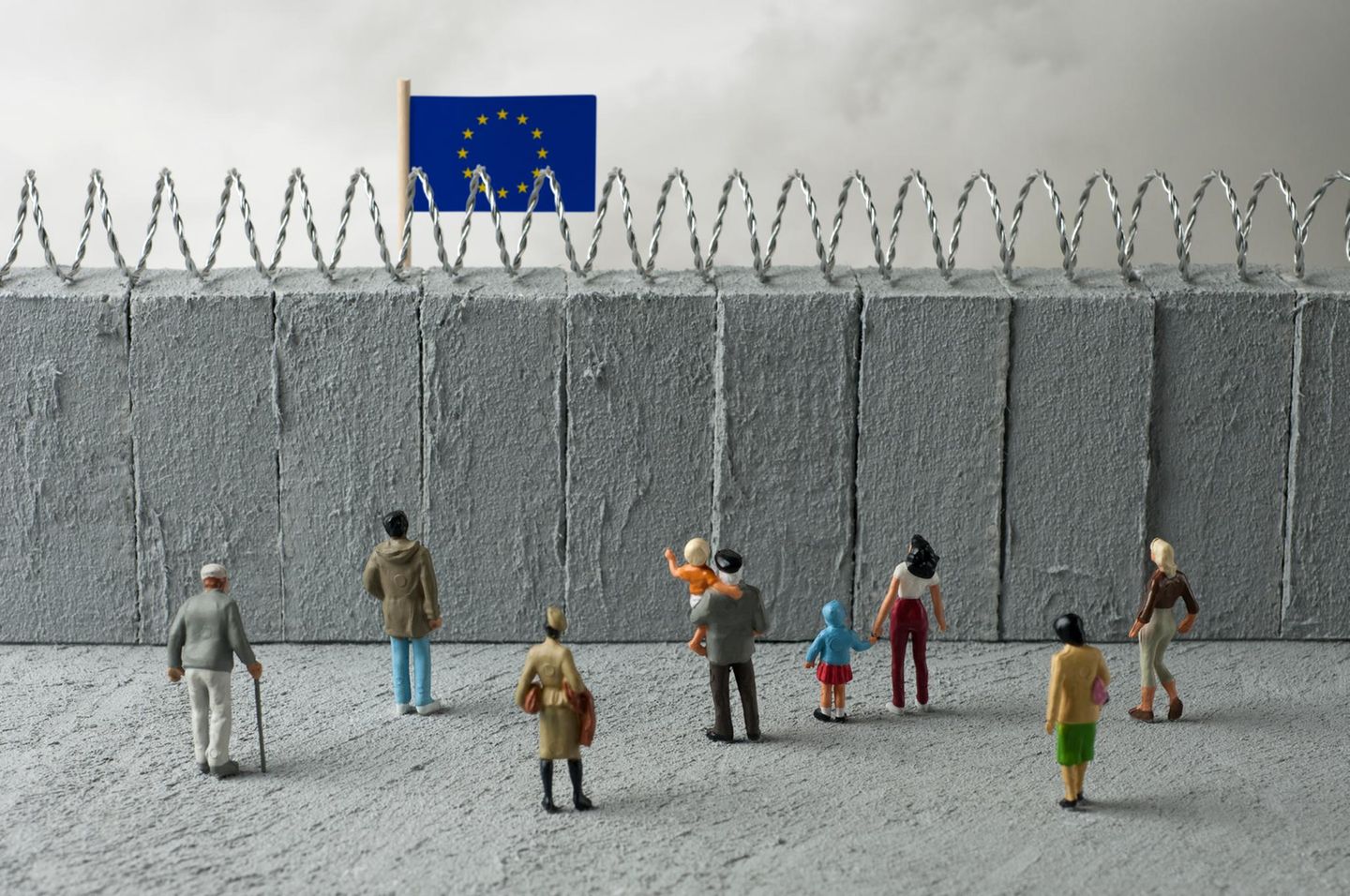 Miniatur-Modell: Eine Mauer trennt die EU von kleinen Modell-Menschen, die darauf zugehen.