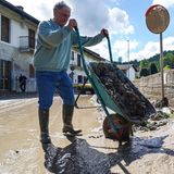 Schubkarren voller Schlamm leert dieser Anwohner aus dem 840-Einwohner-Dorf