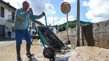 Schubkarren voller Schlamm leert dieser Anwohner aus dem 840-Einwohner-Dorf