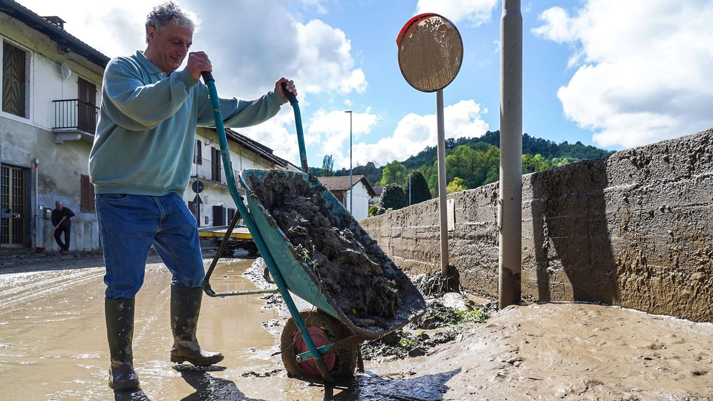 Schubkarren voller Schlamm leert dieser Anwohner aus dem 840-Einwohner-Dorf