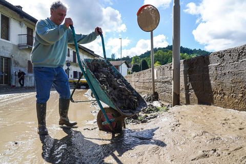 Schubkarren voller Schlamm leert dieser Anwohner aus dem 840-Einwohner-Dorf