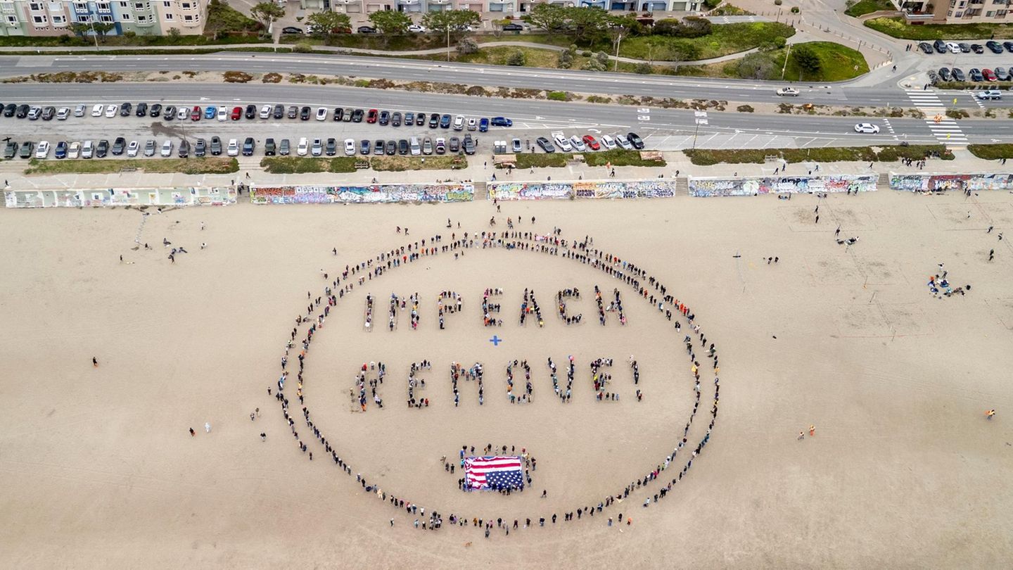 Am Strand von San Francisco versammeln sich Demonstranten für eine Nachricht an Donald Trump. Sie fordern die Amtsenthebung des US-Präsidenten. Bereits in seiner ersten Amtszeit wurden zwei solcher Verfahren angeschoben, das zweite kurz nach der Übergabe der Macht an Joe Biden. Trump ist damit nicht nur der erste Präsident, der zweimal des Amtes enthoben werden sollte – und beide Verfahren überstand – sondern auch der einzige, der nach seiner Amtszeit seines Amtes enthoben werden sollte.