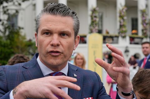 Pete Hegseth gestikuliert, im Hintergrund ist frühlingshafte Deko vor dem Weißen Haus zu sehen