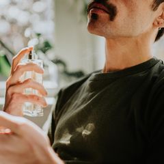 Ein Mann trägt Parfum unter 30 Euro auf