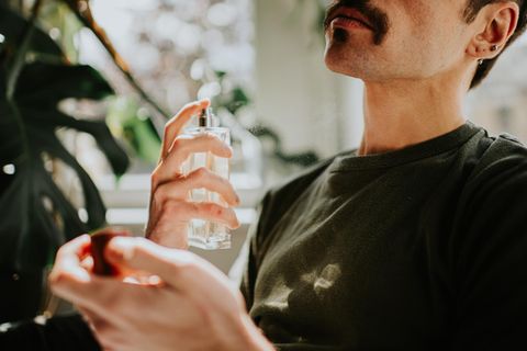 Ein Mann trägt Parfum unter 30 Euro auf