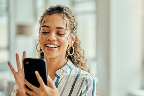 Frau mit Smartphone in der Hand nutzt ChatGPT