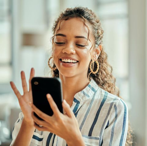 Frau mit Smartphone in der Hand nutzt ChatGPT