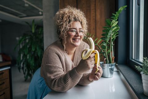 Blutzucker als Dickmacher: Frau isst eine Banane