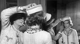 Coco Chanel rückt einen Hut auf Romy Schneiders Kopf zurecht, sie hat dabei eine Zigarette im Mund