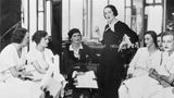 Cooc Chanel sitzt umrahmt voin ihren Kundinnen im Salon von Chanel in Paris