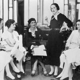 Cooc Chanel sitzt umrahmt voin ihren Kundinnen im Salon von Chanel in Paris