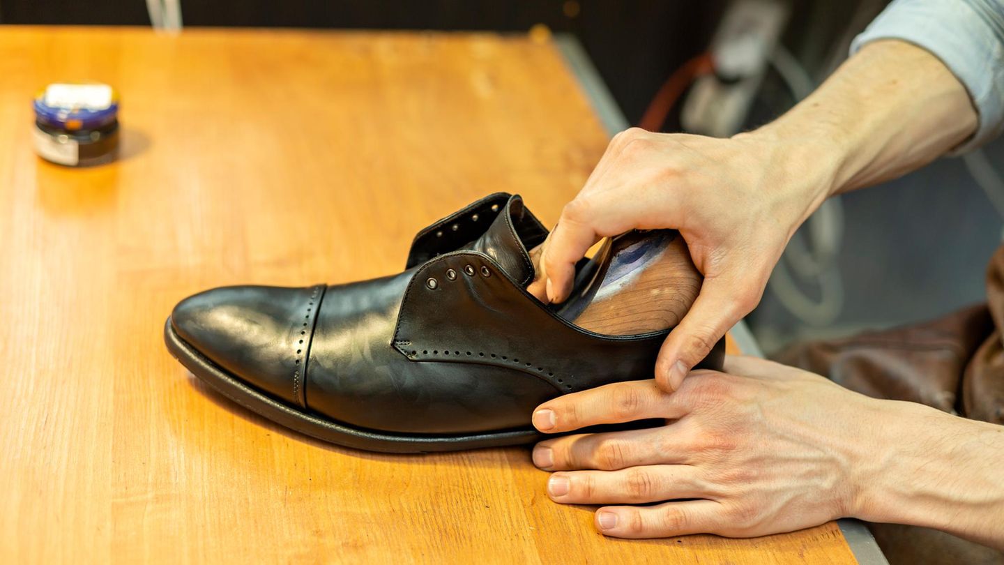 Male craftsperson inserting stretcher in shoe at workshop