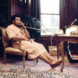Ali 1980 zu Hause in Los Angeles am Telefon, vor ihm auf dem Tisch zwei goldene Fische