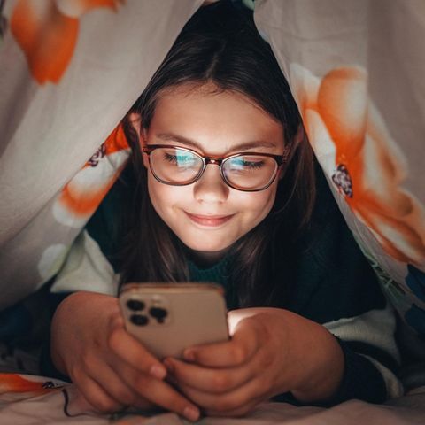 Ein Kind hält ein Smartphone in der Hand
