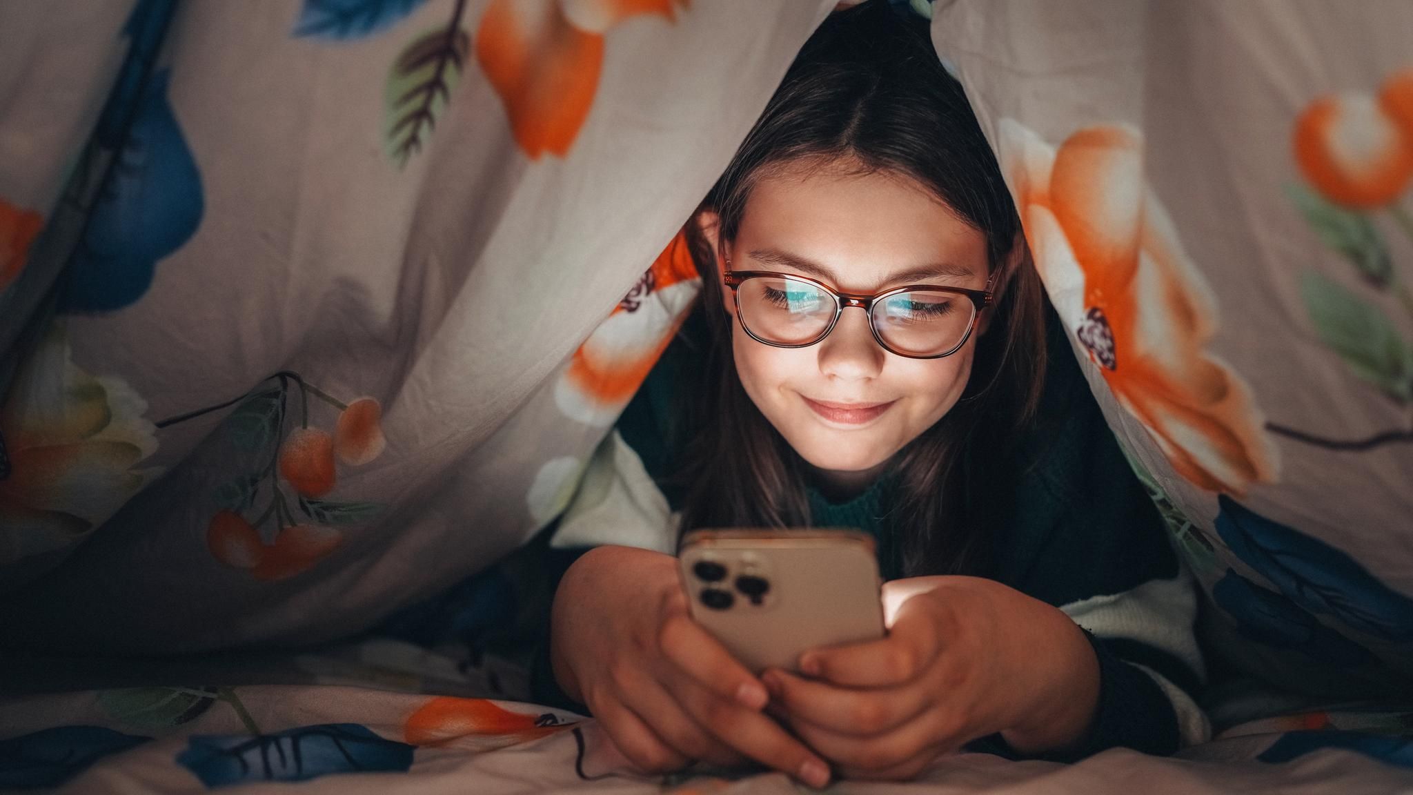 Ein Kind hält ein Smartphone in der Hand