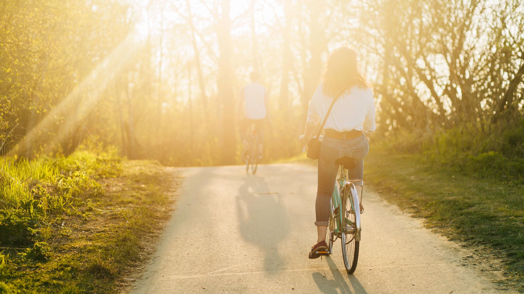 Bewegung: Zwei Fahrradfahrer fahren in den Sonnenuntergang