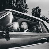 Ali im Rolls-Royce, er schaut aus dem Fahrerfenster. Sein marokkanischer Butler sitzt auf dem Rücksitz.