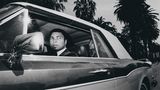 Ali im Rolls-Royce, er schaut aus dem Fahrerfenster. Sein marokkanischer Butler sitzt auf dem Rücksitz.