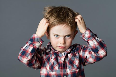 Junge, der sich wegen Läusen die Haare rauft