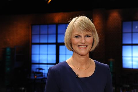 Nachrichtensprecherin Gundula Gause steht im Studio und lächelt in die Kamera.