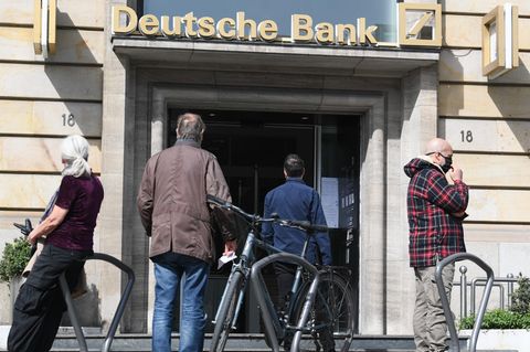 Kunden warten vor einer Filiale der Deutschen Bank in Frankfurt