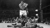Ali nach gewonnenem Kampf gegen Sonny Liston, der am Boden liegt: Ali ballt die Faust und schaut auf ihn runter