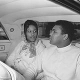 Ali und seine Frau Belinda auf dem Rücksitz eines Autos. Sie hat ein Kopftuch umgeschlungen