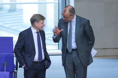 Friedrich Merz steht mit Johann Wadephul im Plenarsaal