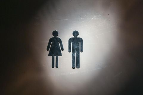 Auf einer Toilettentür sind Piktogramme für einen Mann und eine Frau zu sehen