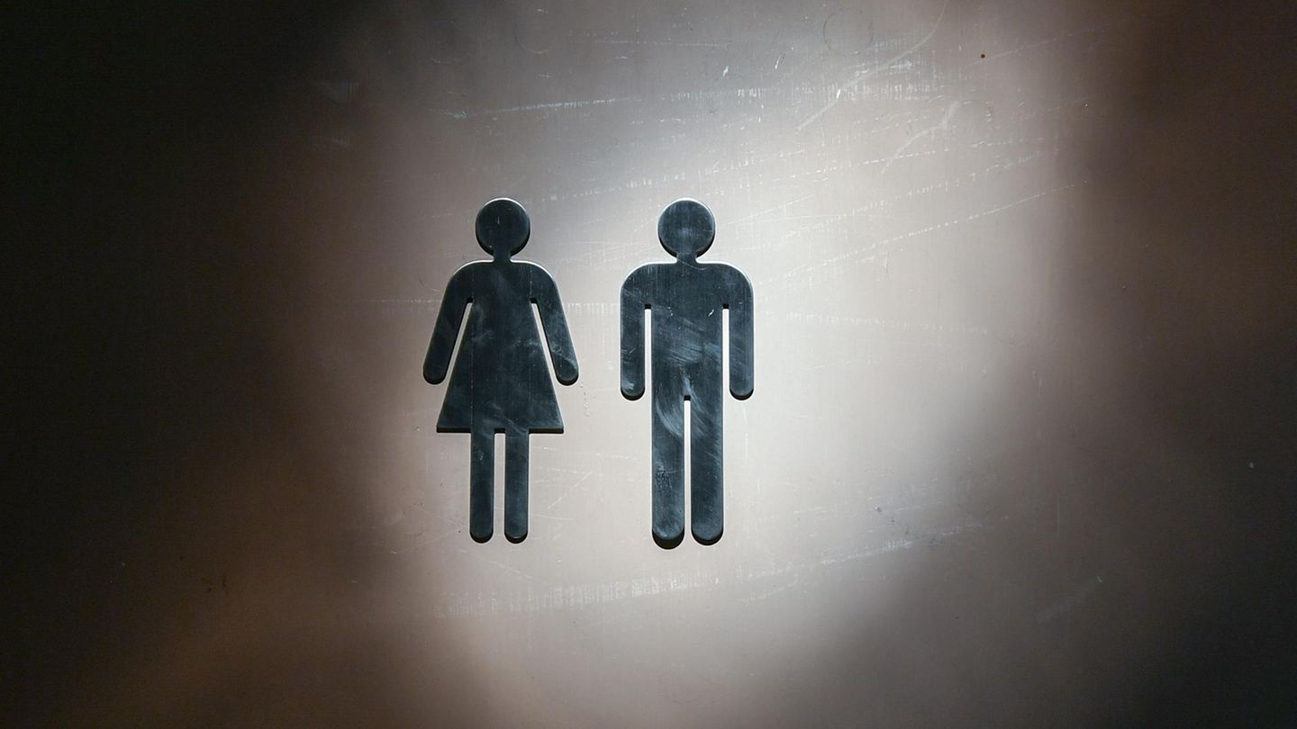 Auf einer Toilettentür sind Piktogramme für einen Mann und eine Frau zu sehen