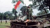 Nordamerikanische Soldaten stehen auf einem Panzer und hissen die Flagge des Vietcong