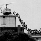 Helikopter steht auf Dach eines Gebäudes, Menschen klettern über eine schmale Treppe zu dem Helikopter