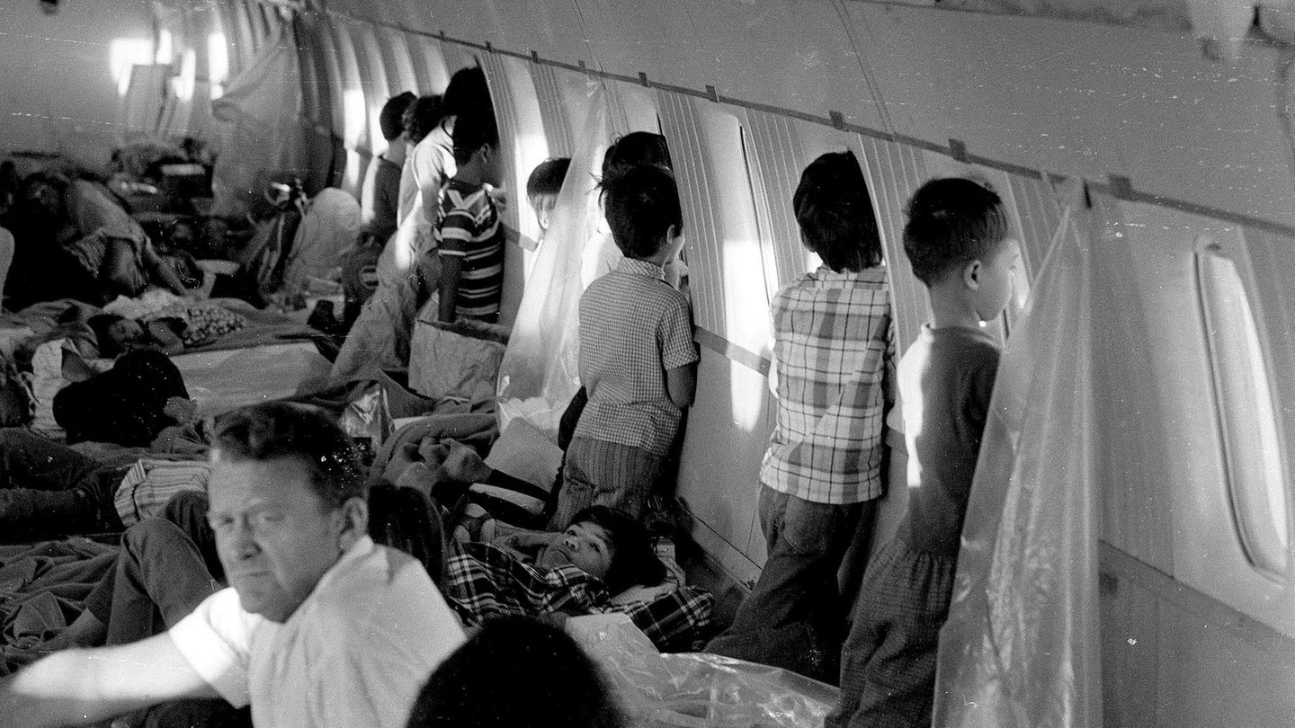 Kinder des Krieges Kinder an Bord eines Flugzeugs stehen an den Fenstern und schauen nach draußen. Am Boden liegen weitere Kinder und schlafen