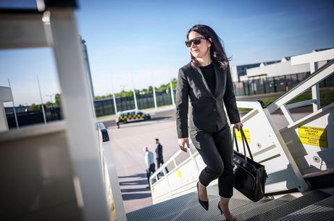 Annalena Baerbock steigt mit Sonnenbrille in ein Flugzeug